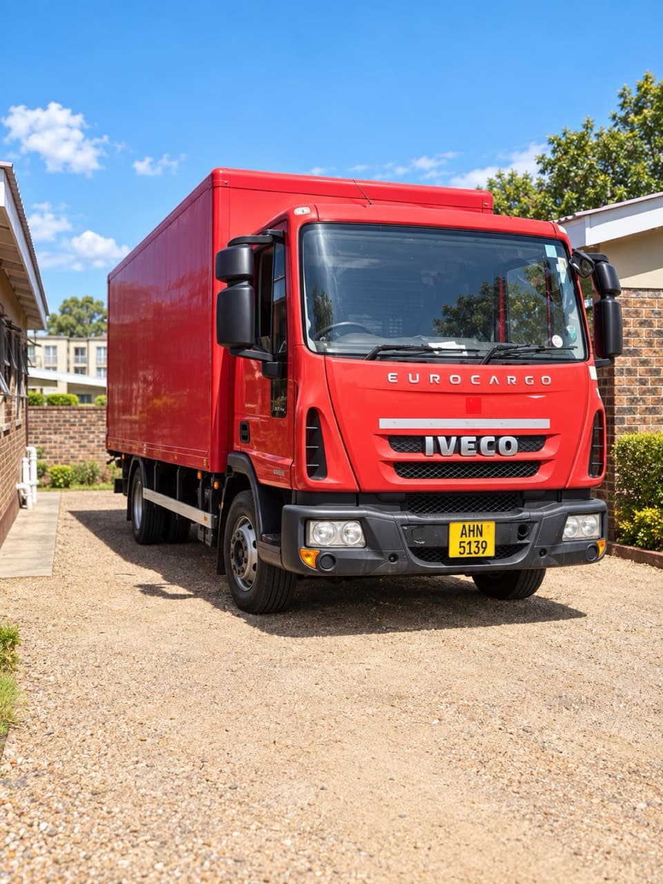 Front three-quarter view of the red Iveco box truck